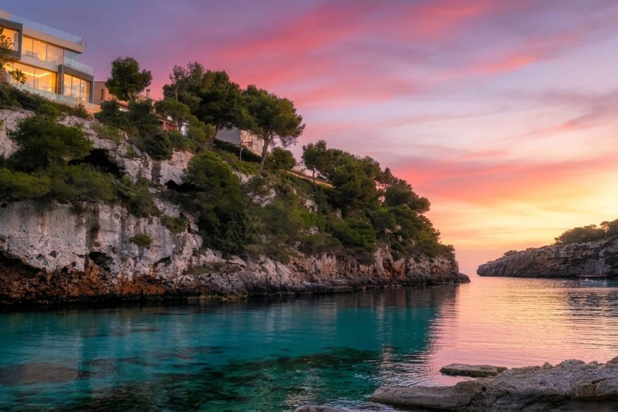 Blick auf türkisfarbenes Meer, Felsküste und Abendsonne in Cala Pi