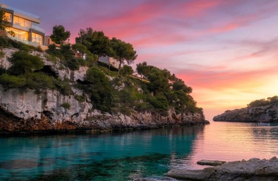 Blick auf türkisfarbenes Meer, Felsküste und Abendsonne in Cala Pi